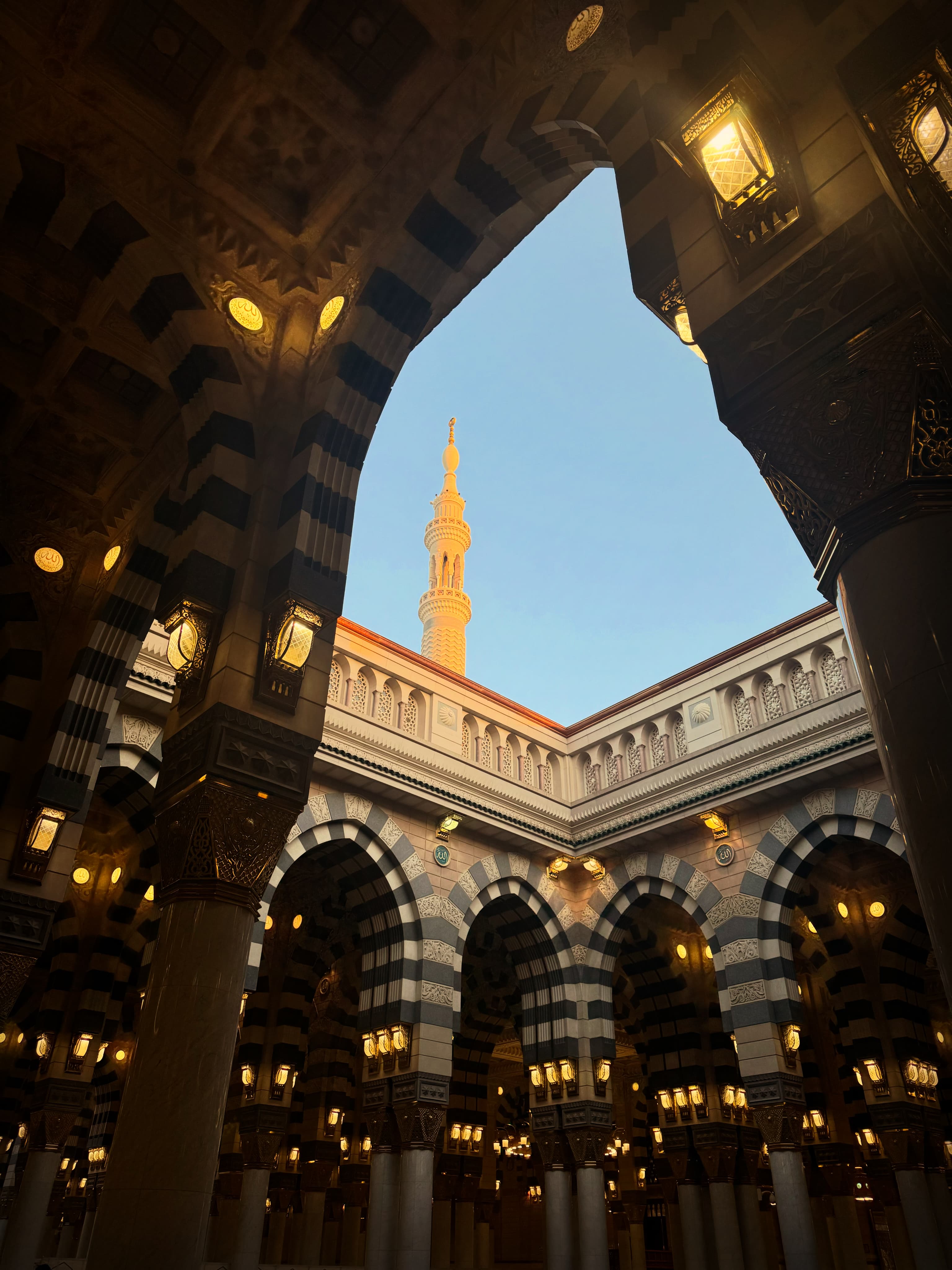 Ornate arches, hanging lanterns, and a minaret.